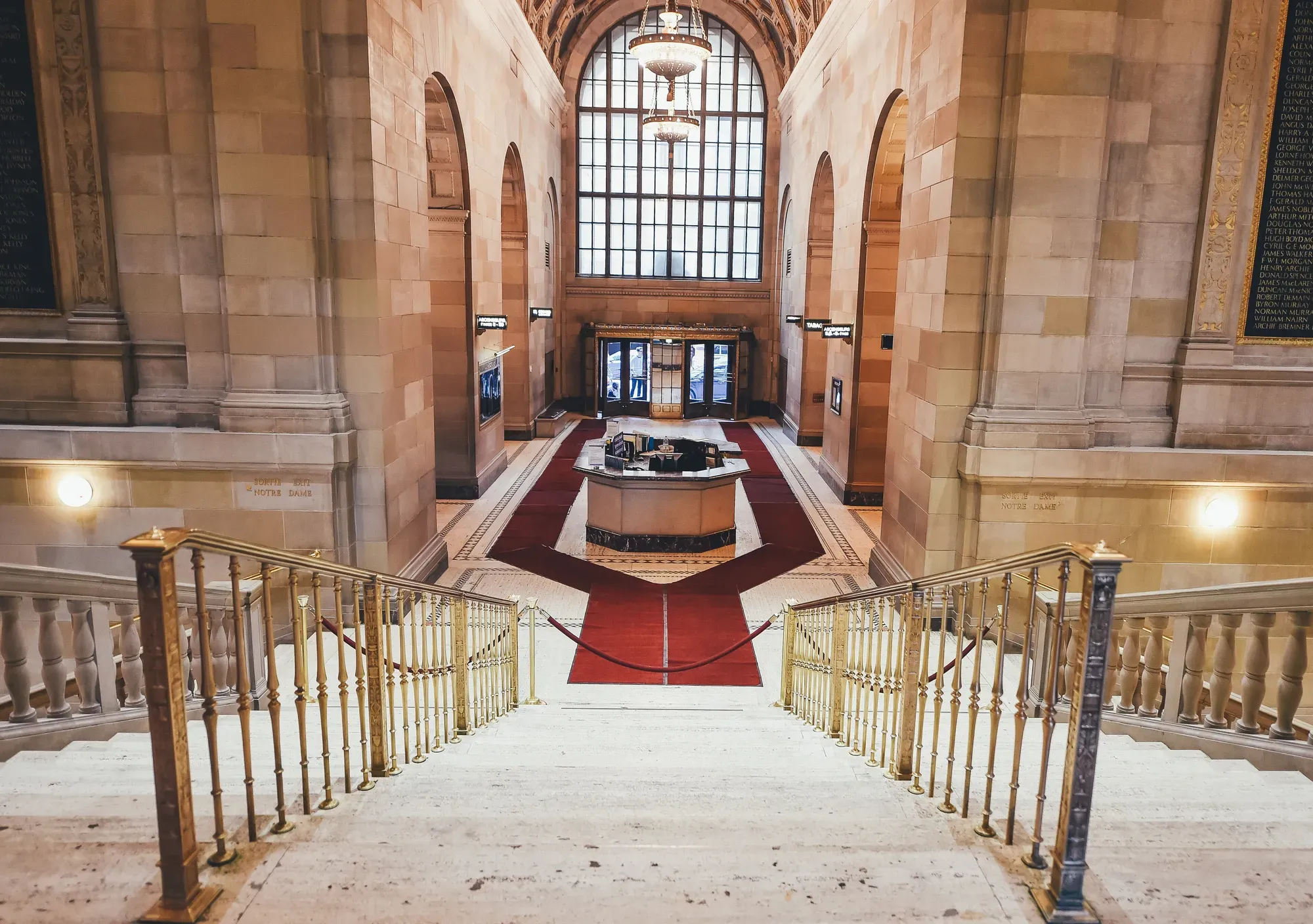 Eine Eingangshalle aus Marmor mit großer Treppe und Messinggeländer